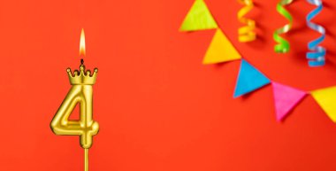 Turuncu arka planda 4 numaralı doğum günü mumu.