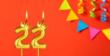 22 numaralı mum - Turuncu arka planda flama ile doğum günü kutlaması