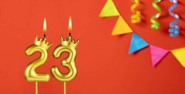 Turuncu arka planda 23 numaralı doğum günü mumu.