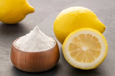 Sarı limon meyvesi ve kabın içinde kabartma tozu.