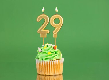 29 numaralı doğum günü mumu. Yeşil arka planda kek.