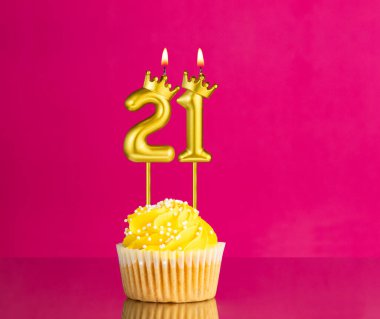 21 numaralı mumla doğum günü kutlaması - Pembe arka planda sarı kek