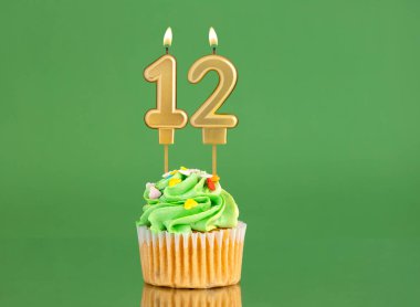 Mumlu ve kekli doğum günü kartı. Yeşil arka planda 12 numara.
