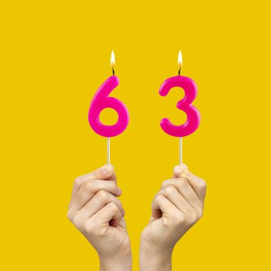 63 numaralı doğum günü - Fuşya renkli mumlar tutan eller