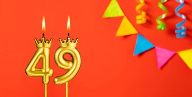Turuncu arka planda 49 numaralı doğum günü mumu.