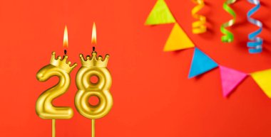28 numaralı mum - Turuncu arka planda flama ile doğum günü kutlaması