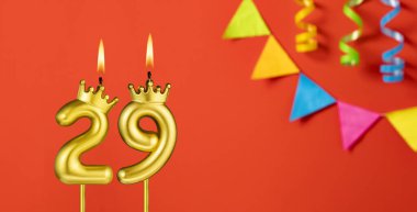 29 numaralı doğum günü mumu turuncu arka planda flama ile