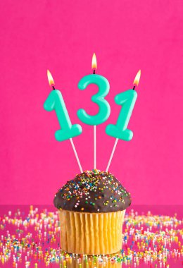 131 numaralı mumlu doğum günü keki fuşya arka planında kutlama kartı.
