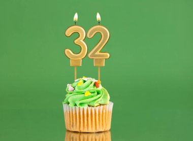 Mumlu ve kekli doğum günü kartı. Yeşil arka planda 32 numara.