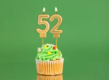 Mumlu ve kekli doğum günü kartı. Yeşil arka planda 52 numara.