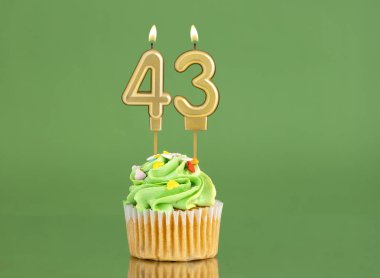 43 numaralı doğum günü mumu. Yeşil arka planda kek.