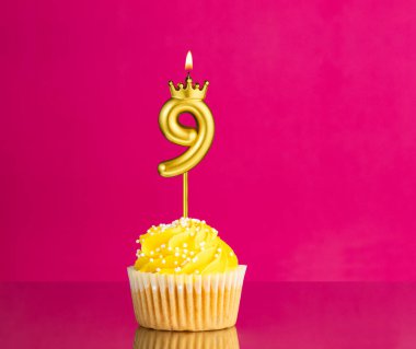 9 numaralı mumla doğum günü kutlaması - Pembe arka planda sarı kek