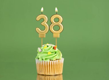 Mumlu ve kekli doğum günü kartı. Yeşil arka planda 38 numara.