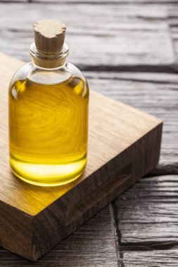 Tahta üzerinde bakire yağı olan bir şişe. Kırsal arka plan.