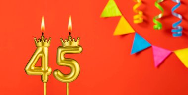 Turuncu arka planda 45 numaralı doğum günü mumu.
