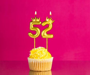 52 numaralı mumla doğum günü kutlaması - Pembe arka planda sarı kek