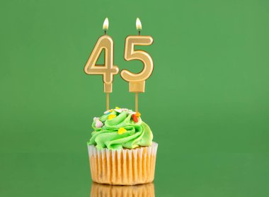 45 numaralı doğum günü mumu. Yeşil arka planda kek.