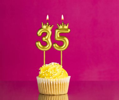 35 numaralı mumla doğum günü kutlaması - Pembe arka planda sarı kek