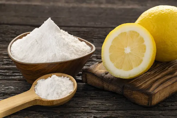 Kabartma tozu ve dilimlenmiş limonla kase kaşık. Limon.