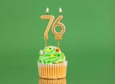 Mumlu ve kekli doğum günü kartı. Yeşil arka planda 76 numara.