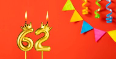 62 numaralı mum - Turuncu arka planda flama ile doğum günü kutlaması