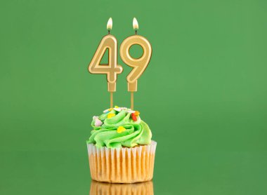 49 numaralı doğum günü mumu. Yeşil arka planda kek.