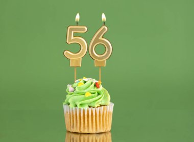 Mumlu ve kekli doğum günü kartı. Yeşil arka planda 56 numara.