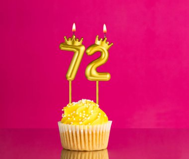 72 numaralı mumla doğum günü kutlaması - Pembe arka planda sarı kek