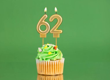Mumlu ve kekli doğum günü kartı. Yeşil arka planda 62 numara.