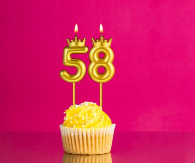 58 numaralı mumla doğum günü kutlaması - Pembe arka planda sarı kek