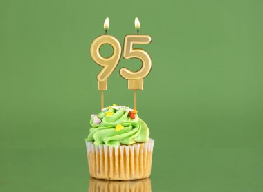 95 numaralı doğum günü mumu. Yeşil arka planda kek.