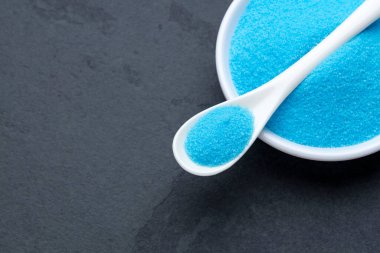 Bir kase ve kaşıkta mavi tuz kristalleri - potasyum florür