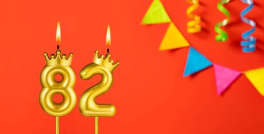 82 numaralı mum - Turuncu arka planda flama ile doğum günü kutlaması