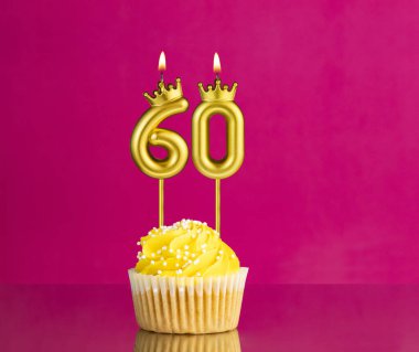 60 numaralı mumla doğum günü kutlaması - Pembe arka planda sarı kek