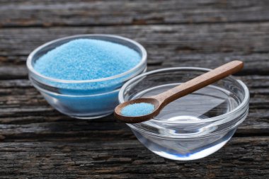 Bir kase su ve mavi maden tuzu ile bir kaşık.