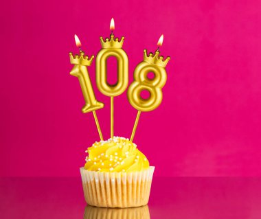 108 numaralı mumla doğum günü kutlaması - Pembe arka planda sarı kek