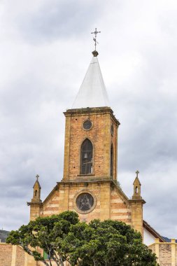 Raquira, Boyaca, Kolombiya. 11 Mayıs 2025. Kasabanın ana kilisesinin panoramik drone görüntüsü.