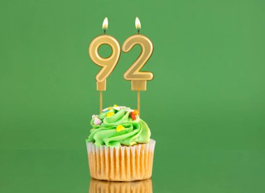 Mumlu ve kekli doğum günü kartı. Yeşil arka planda 92 numara.