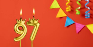 Turuncu arka planda 97 numaralı doğum günü mumu.