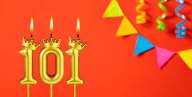 Turuncu arka planda 101 numaralı doğum günü mumu.