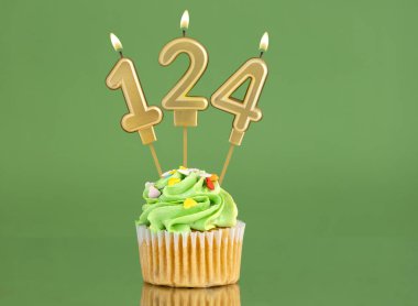 Mumlu ve kekli doğum günü kartı. Yeşil arka planda 124 numara.