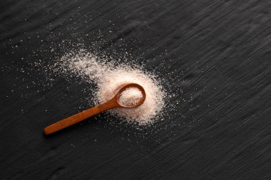 Kaşık üzerinde ince tuz ve pembe Himalaya kristalleri.