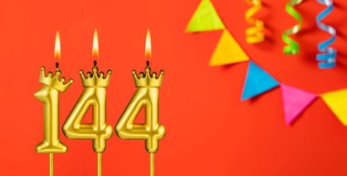 144 numaralı mum - Turuncu arka planda flama ile doğum günü kutlaması