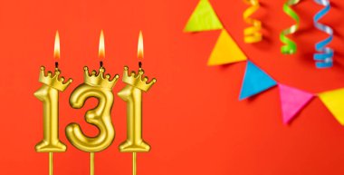 Turuncu arka planda 131 numaralı doğum günü mumu.