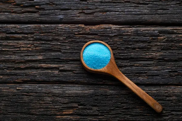Kaşıkta mavi tuz kristalleri, potasyum florür. Cam kenarı için tuz.