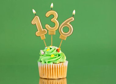 Mumlu ve kekli doğum günü kartı. Yeşil arka planda 136 numara.