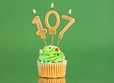 107 numaralı doğum günü mumu - Yeşil arka planda kek
