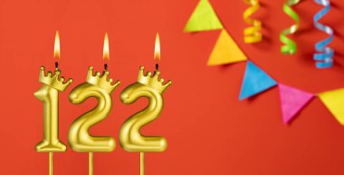 122 numara mum - Turuncu arka planda flama ile doğum günü kutlaması