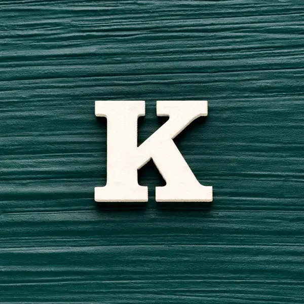 Büyük harf K, koyu yeşil arka planda beyaz harf.