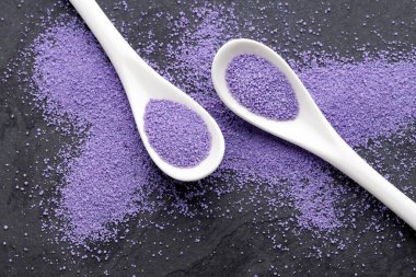 İki kaşıkta mor renkli yaban mersini aromalı şeker.